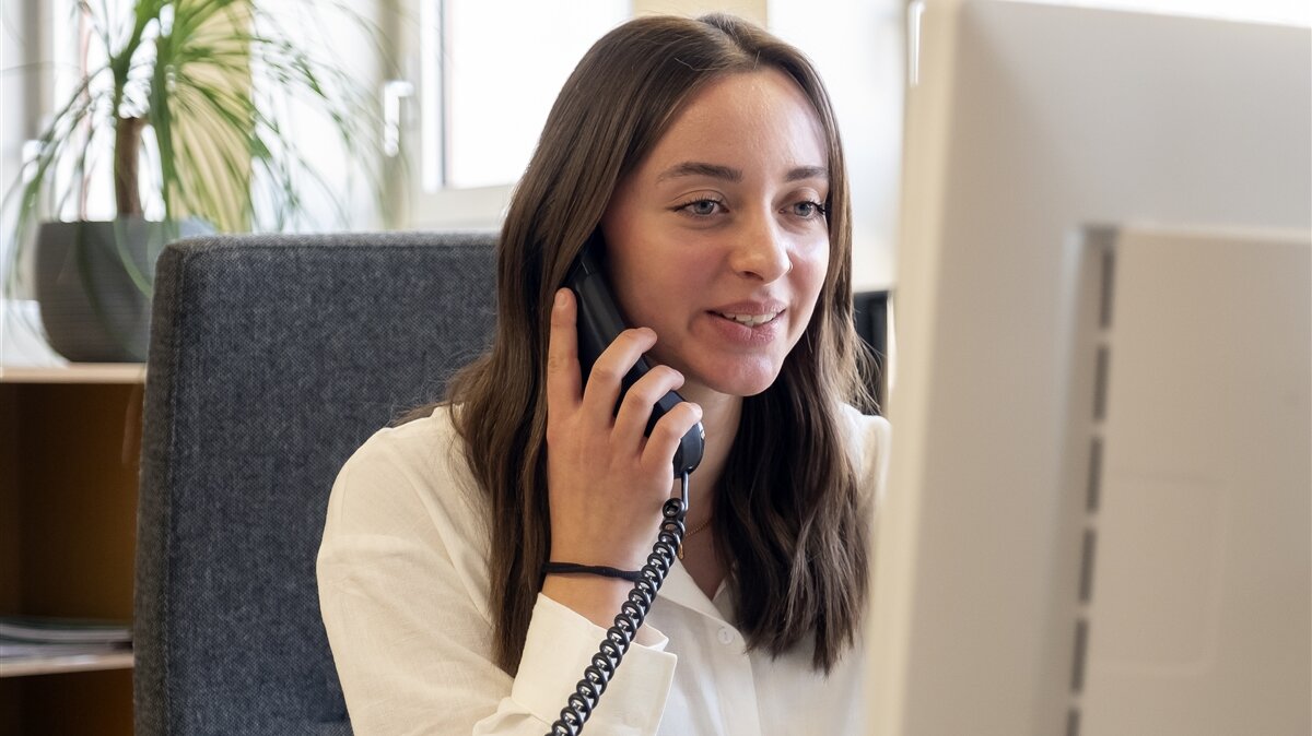Im Büro beantwortet Eva am Telefon Fragen und erteilt Auskünfte.