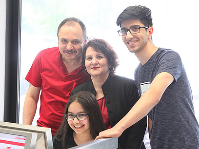 Eine Familie informiert sich über die Berufswahl des eigenen Kindes am Computer.