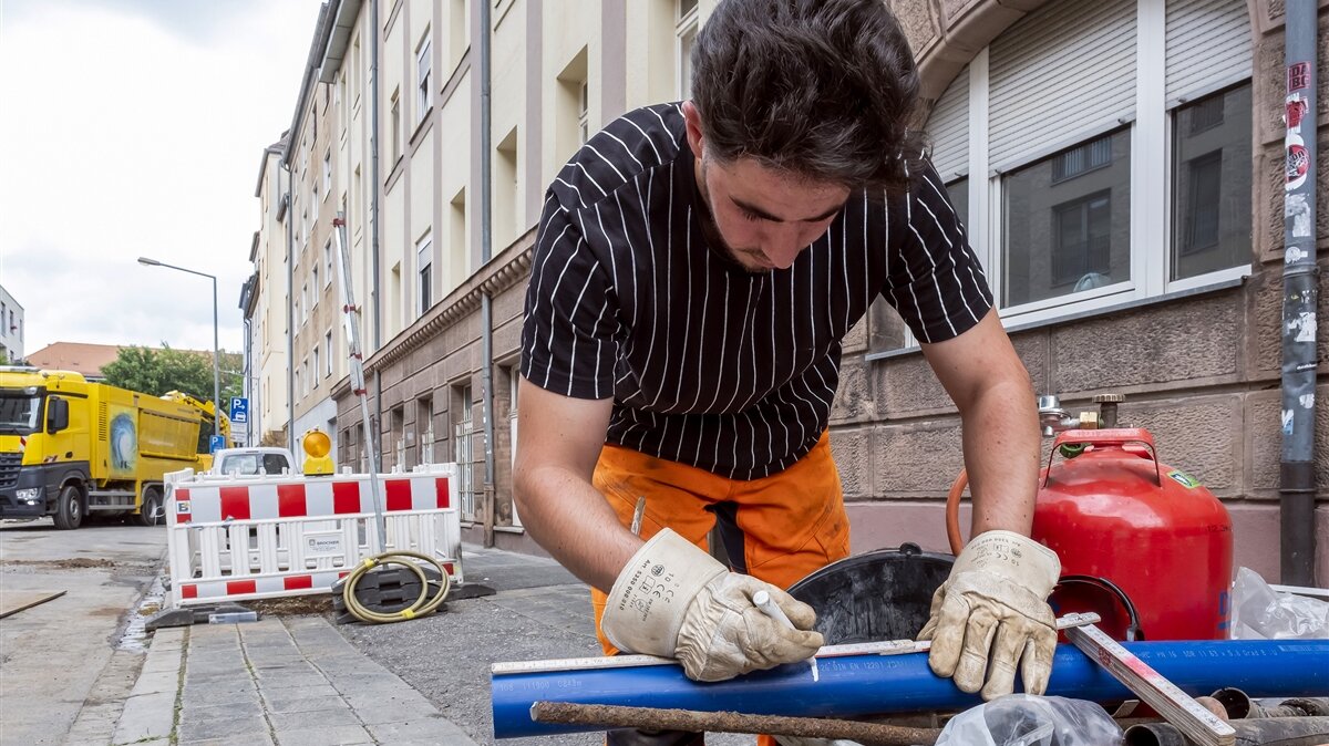 Jaafar zeichnet die Schnittstelle auf einem Rohr an.