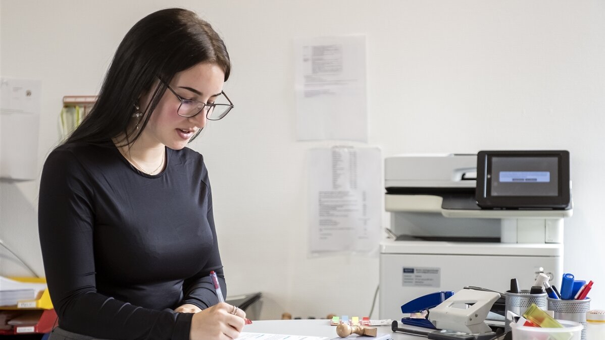 Leanna füllt ein ausgedrucktes Formular aus.