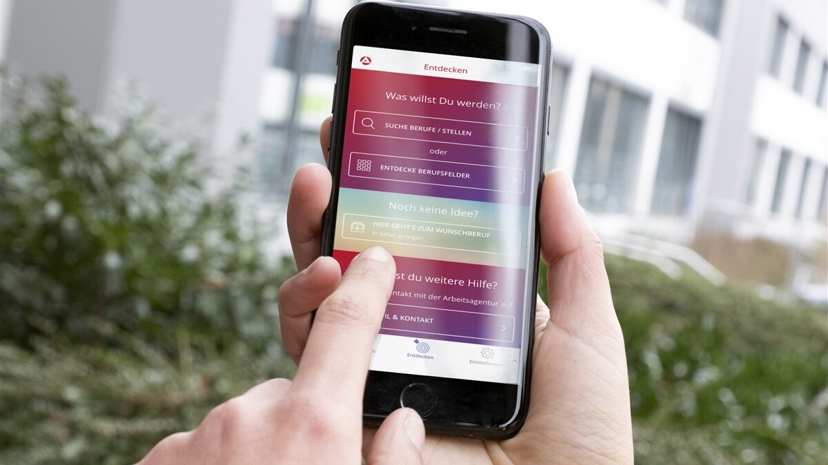 Hand tippt auf einem Smartphone-Bildschirm und informiert sich nach Berufsideen.