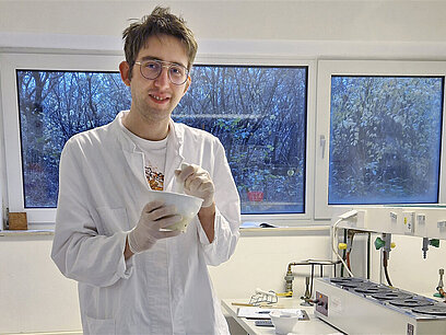 Jan-Frederik rührt in einer Schale im Labor.