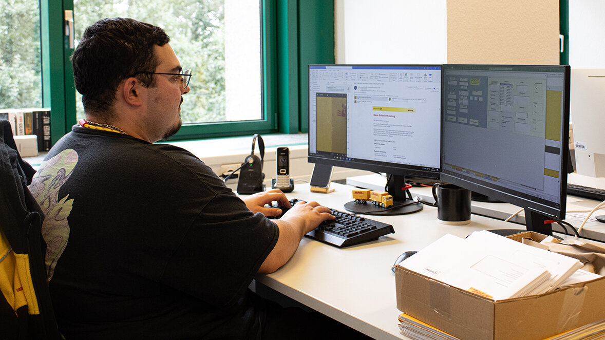 Michael sitzt im Büro und bearbeitet am Computer die Unfallstatistik.