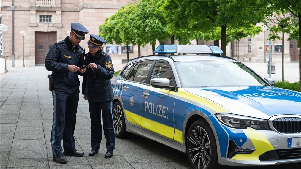 Ein Polizist und eine Polizistin besprechen ihren Einsatz.