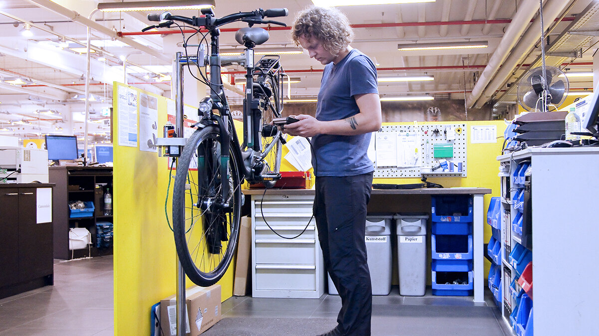Ein Zweiradmechatroniker repariert ein Fahrrad.