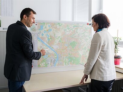 Ein Mann und eine Frau sprechen über eine Landkarte.