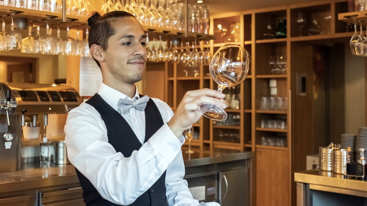 Ein junger Mann schaut sich ein poliertes Glas an.