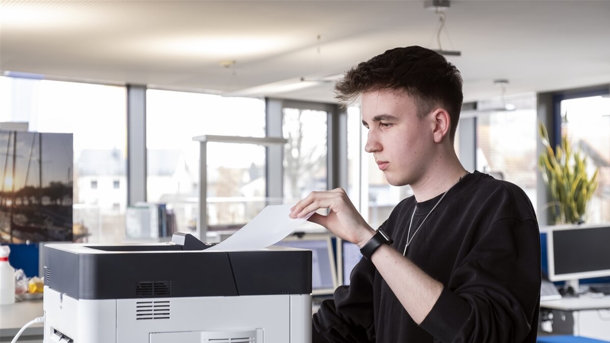 Im Büro holt Maximus Frachtrechnungen aus dem Drucker.