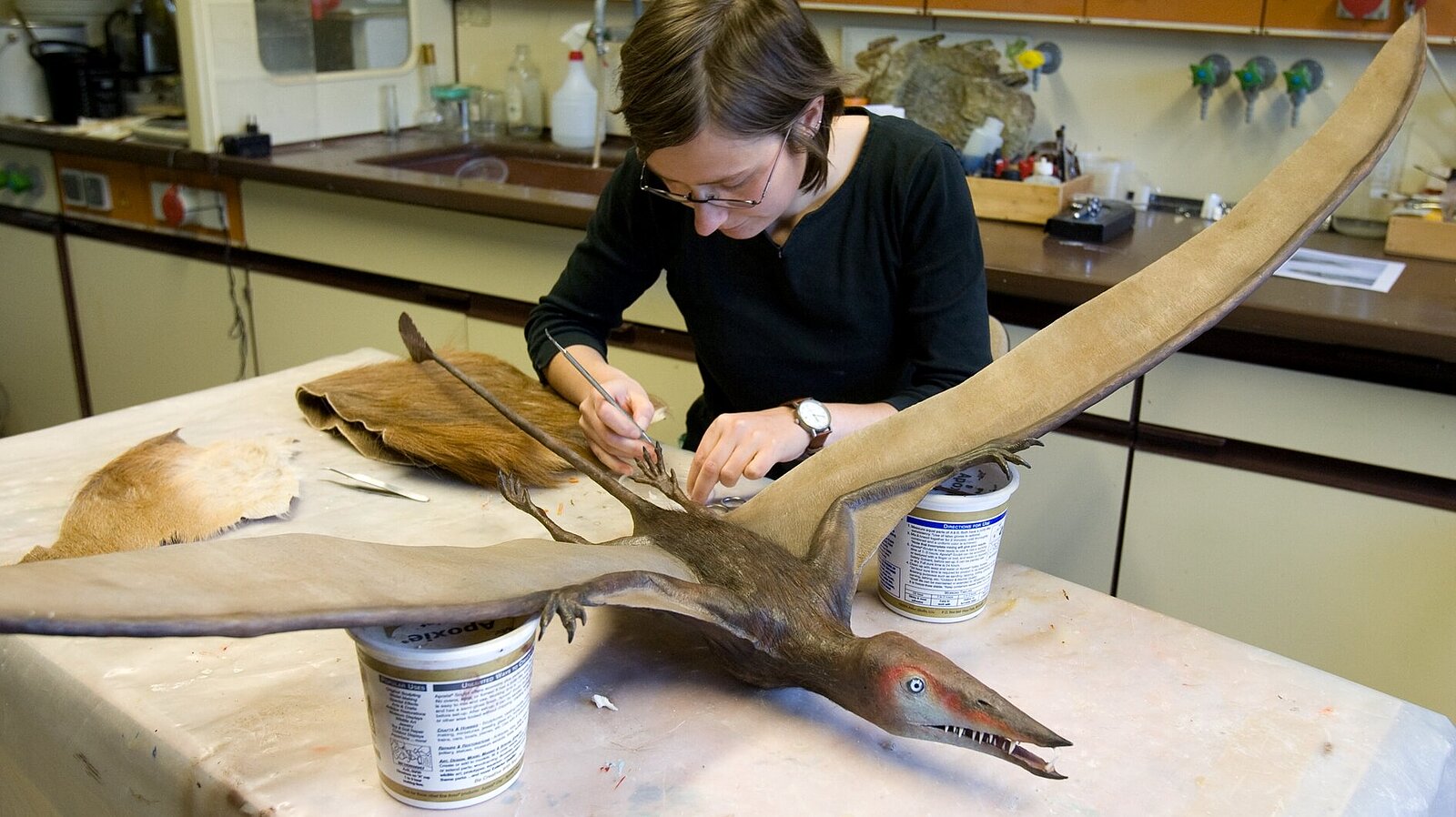 Eine Frau stellt ein Flugsauriermodell her.