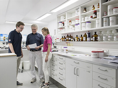 Ein Mann bespricht sich mit zwei jungen Menschen im Labor.