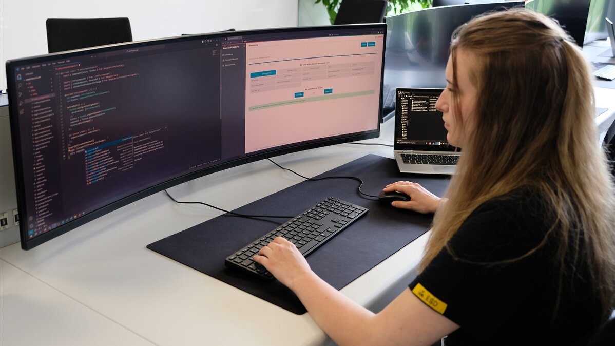 Ayliah sitzt vor ihrem Computer und bedient Maus und Tastatur.