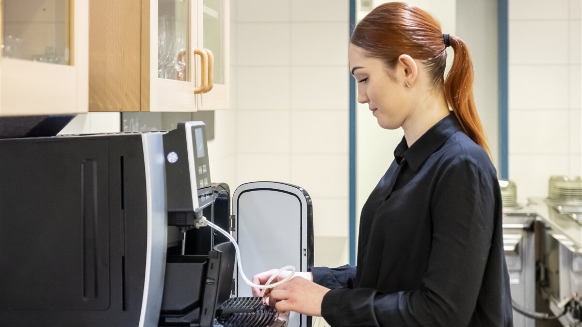 Andreea bereitet die Kaffeemaschine vor.