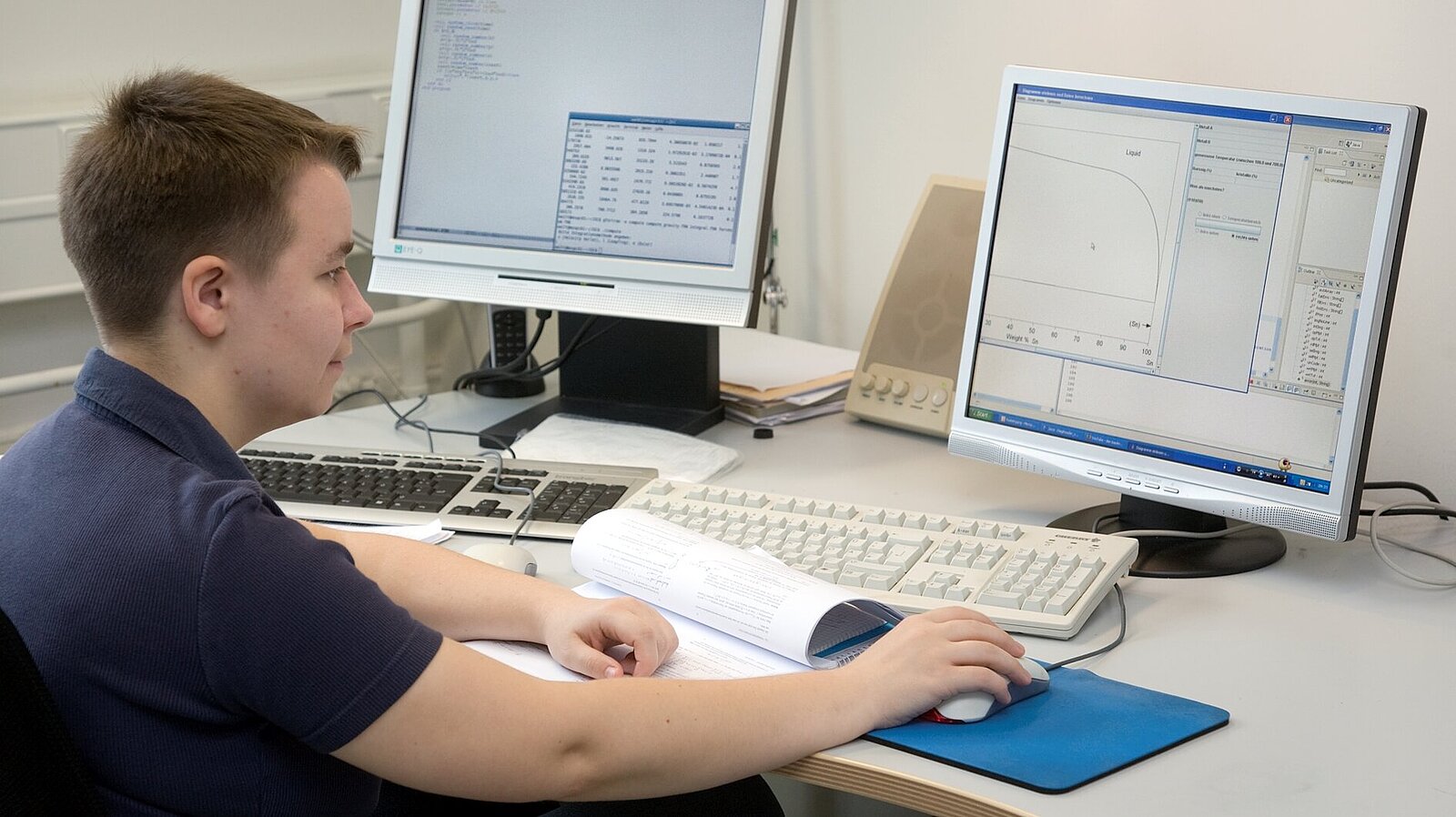 Ein Mitarbeiter programmiert komplexe Softwaresysteme am Computer.
