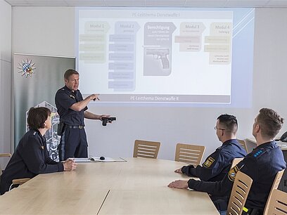 Ein Polizist gibt Polizistenanwärter/innen Unterricht.