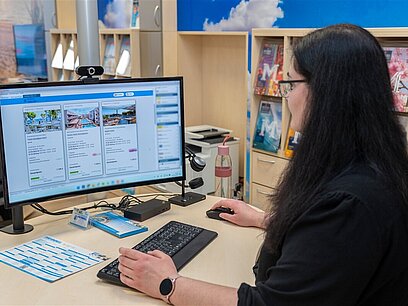 Eine junge Frau arbeitet an einem Computer.