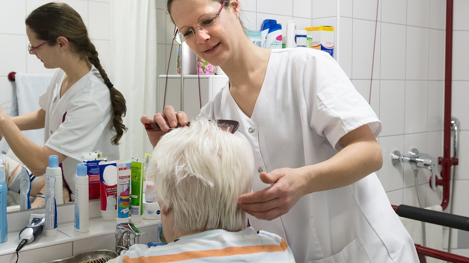Eine Frau hilft einer Patientin bei der Körperpflege.