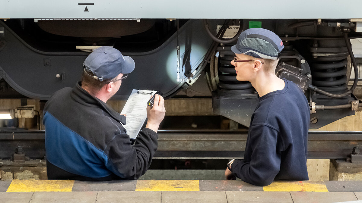 Tom und der Vorhandwerker gehen Toms Arbeiten an dem Zug durch. 