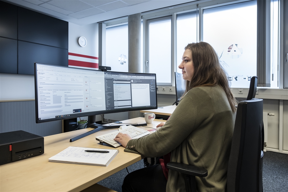 Sonja bearbeitet E-Mails an ihrem Arbeitsplatz.