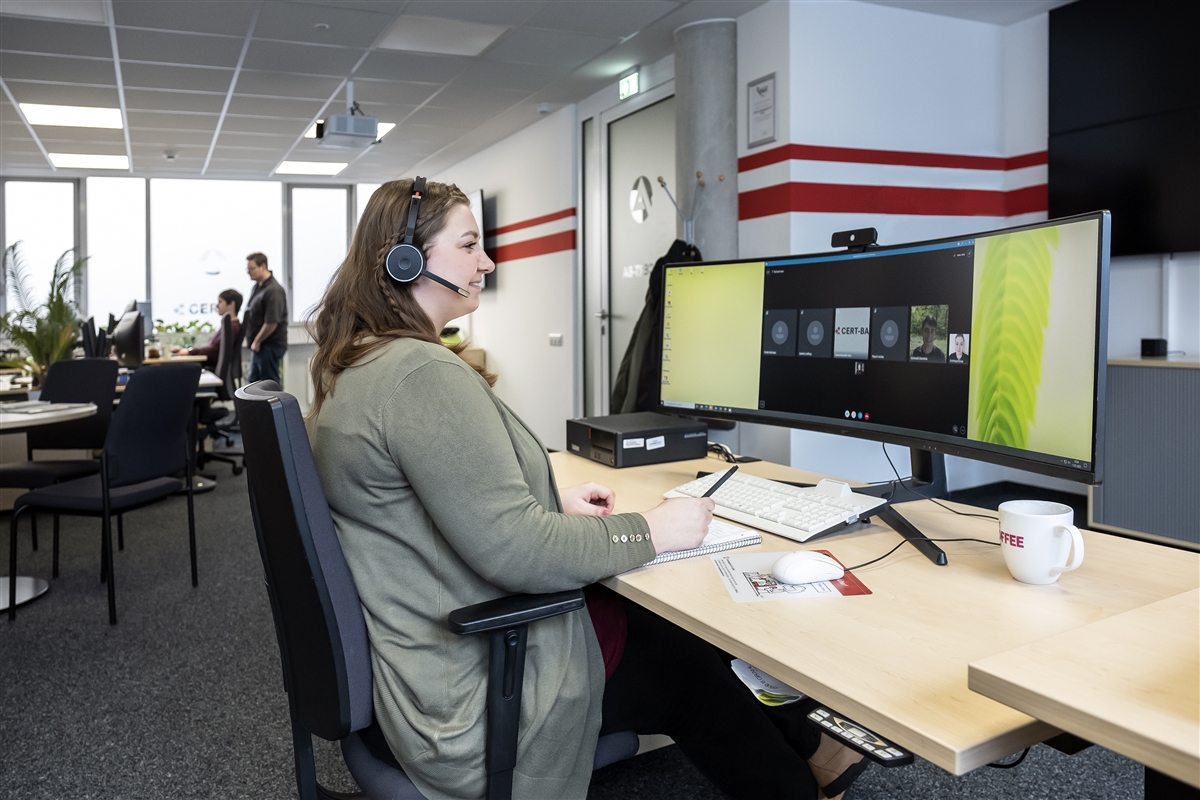 Sonja nimmt von ihrem Arbeitsplatz aus an einer Videokonferenz teil. 