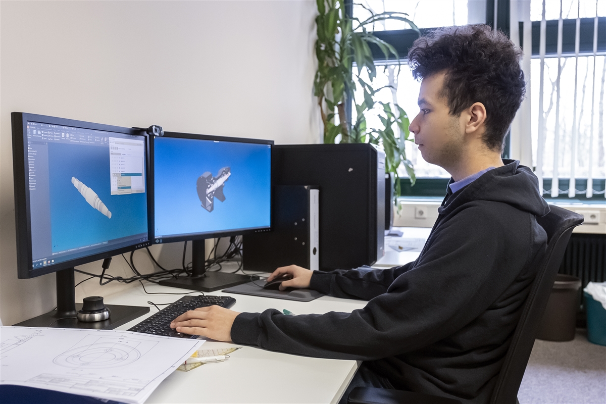 Michael sitzt am PC und entwirft eine 3D-Konstruktion.