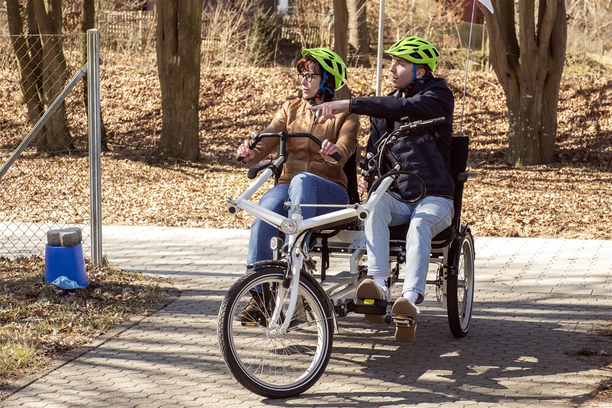 Moritz fährt mit einer Frau auf einem Tandem-Fahrrad.