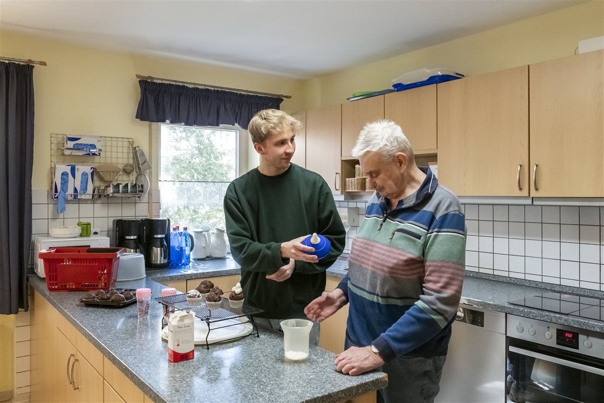 Moritz backt mit einem älteren Mann Muffins.