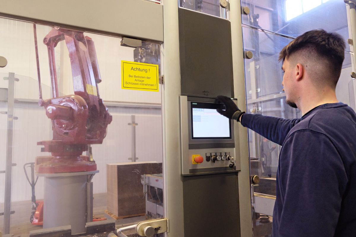 Maciej bedient das Display der Palettier- und Verpackungsanlage.