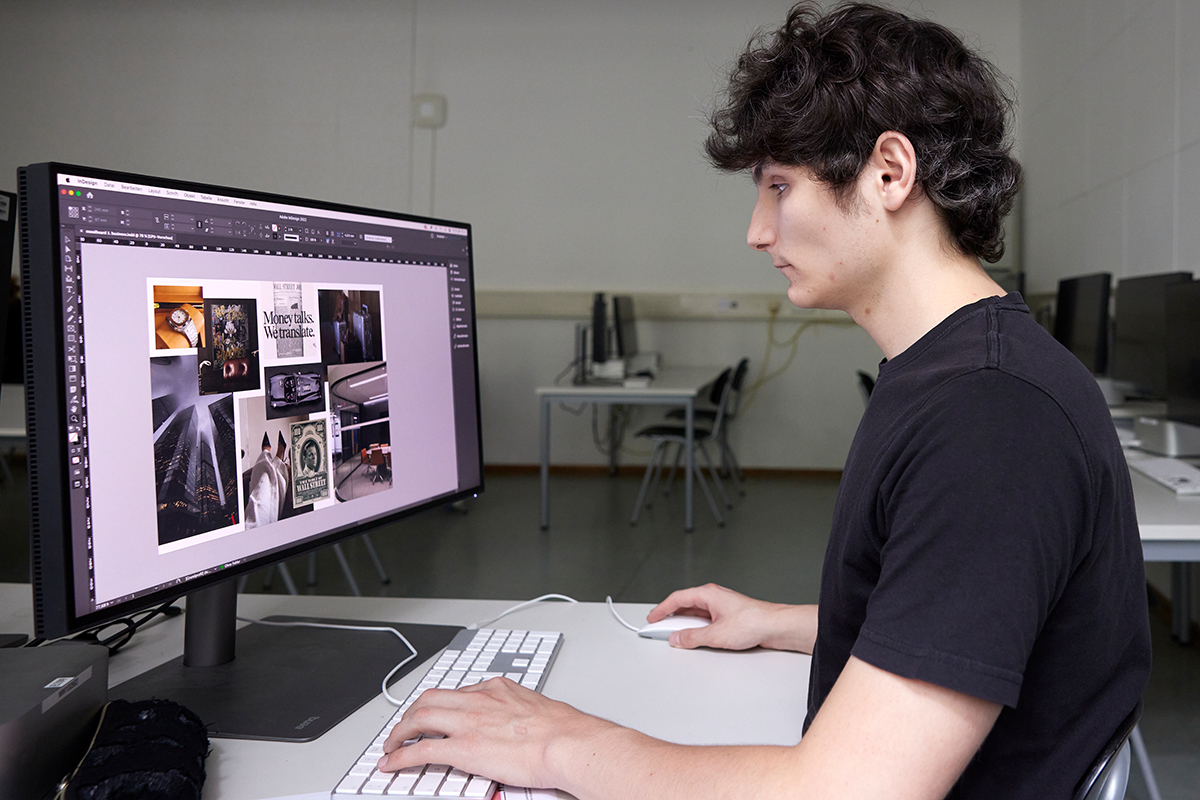 Paul sitzt im Klassenzimmer am Computer und sammelt Bildmaterial.