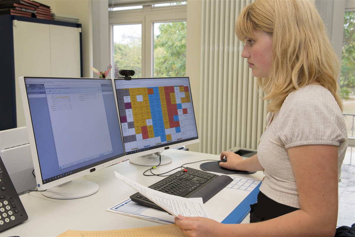 Emily legt am Computer eine Personalakte an.