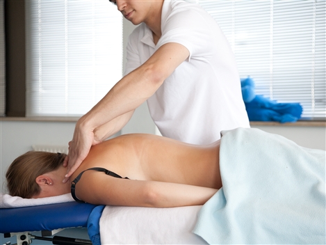 Ein Physiotherapeut massiert eine Patientin.